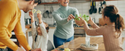 Home remodeling services that provide more family space. Happy parents and their daughters having fun while preparing meal together at home.